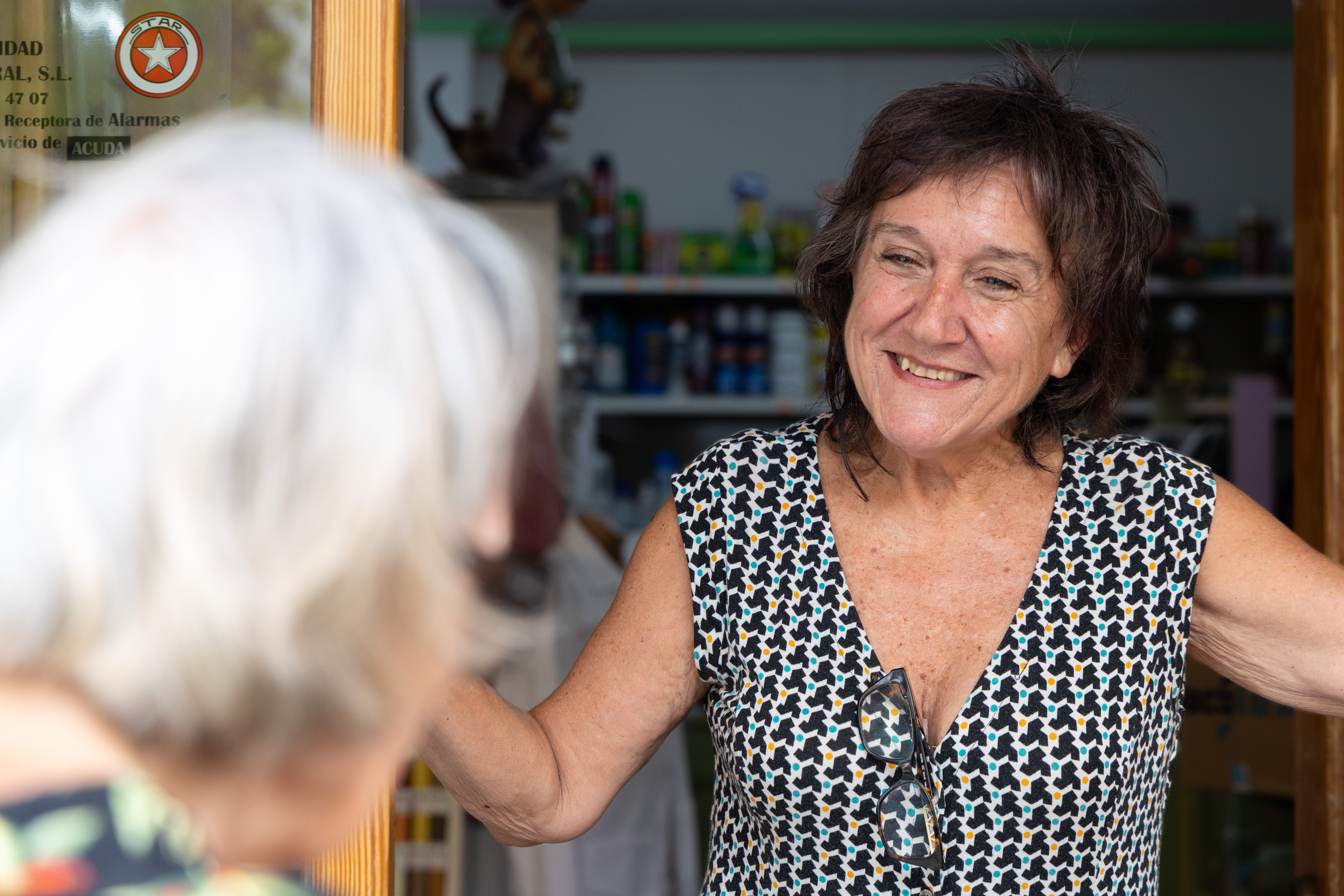 Adela atenent al taulell de la seua botiga